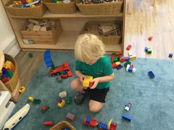 Unique child montessori child playing with colorful blocks