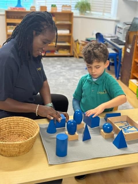 Practitioner and child exploring montessori materials at northolt